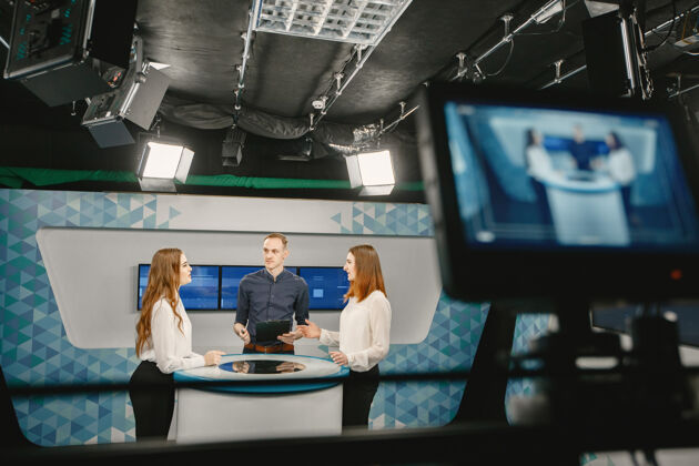 职业摄像机取景器-在电视演播室录制节目-聚焦在摄像机上商务女性采访记者