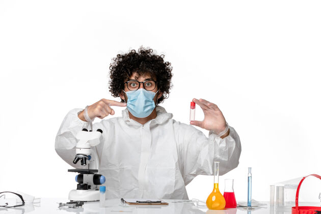 大流行正面图：男医生穿着防护服 戴着面罩 拿着浅白色的样品实验室外套医学外套