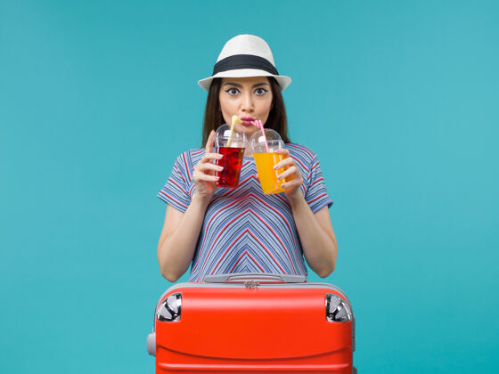 肖像度假的女人拿着蓝色的新鲜饮料航程可爱成人