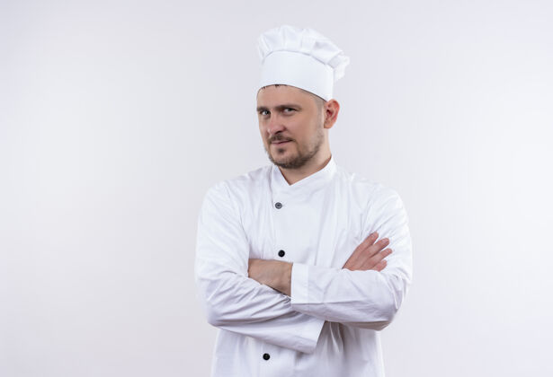 制服自信的年轻帅哥厨师身着厨师制服 以封闭的姿势站在白色的墙上封闭年轻自信