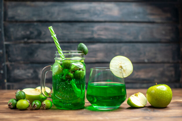 果汁前视图绿色的菲乔果汁与绿色的苹果在一个黑暗的酒吧水果色照片鸡尾酒饮料酒吧杯子柠檬