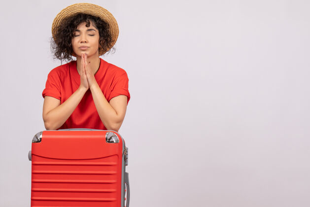 封面女郎正面图年轻女性 带着红包准备旅行 在白色背景上祈祷 度假 阳光 色彩 旅行 休息 旅游飞机年轻女性飞行人