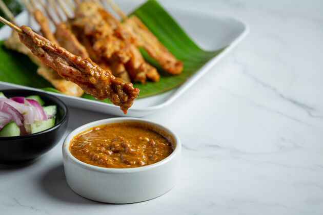 食物猪肉沙爹配花生酱或糖醋酱 泰国菜传统酱汁烹饪