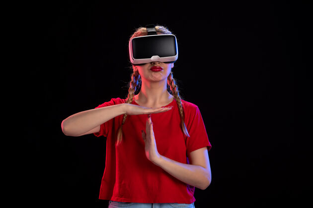 成人年轻女性在黑暗的墙上玩虚拟现实的正面图女士游戏游戏