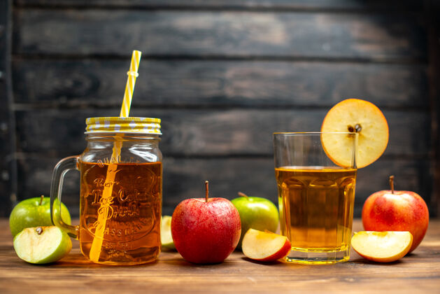 食物正面图新鲜苹果汁内罐与新鲜苹果放在深色桌上颜色鸡尾酒饮料照片水果玻璃鸡尾酒苹果
