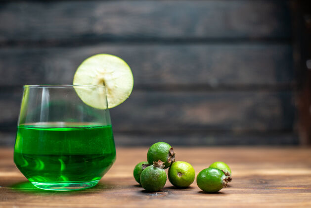 酒吧正面图绿色的菲约亚果汁内杯 绿色的苹果放在木制的桌上吧水果色的饮料照片鸡尾酒食品木材新鲜
