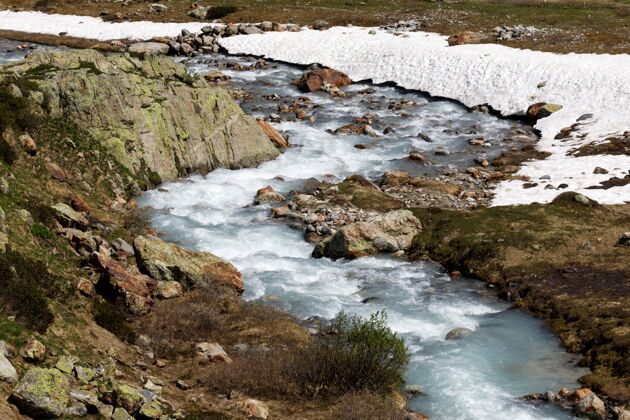 溪流位于瑞士苏斯腾山口的山河在冬天的白天瑞士冰石头