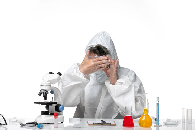 绝育男医生穿着防护服 带着无菌口罩 在白色地板上拿着空瓶 冠状病毒大流行保护药品病毒