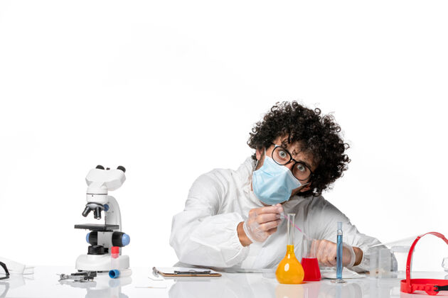 口罩男医生穿着防护服 戴着口罩 用白色溶液工作实验室人大流行