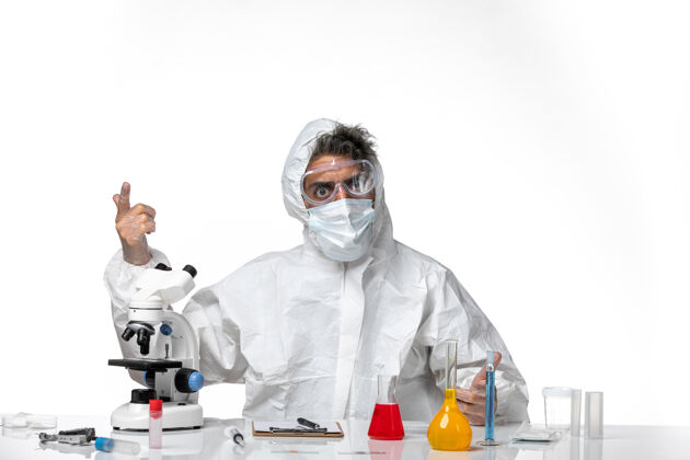 实验室男医生穿着防护服 戴着口罩坐在浅白的床上外套口罩坐姿