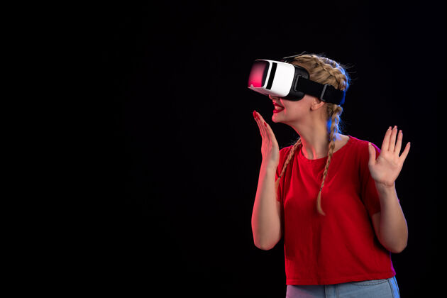 游戏年轻女性在黑暗的墙上玩虚拟现实的正面图肖像虚拟现实成人