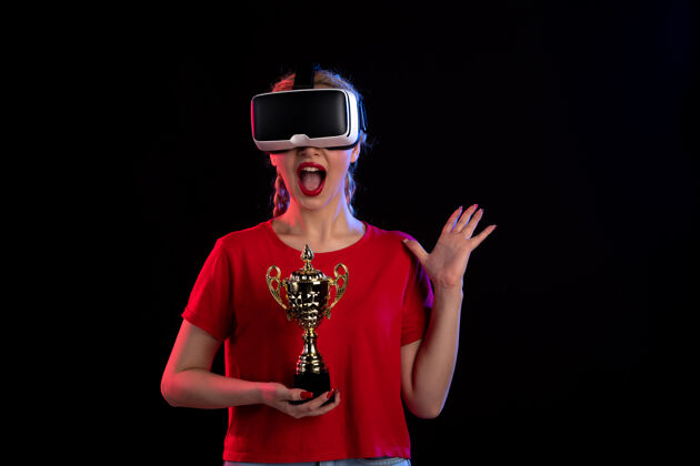 人物在黑暗的墙壁上 年轻女性正在玩虚拟现实和冠军杯视图游戏年轻女性