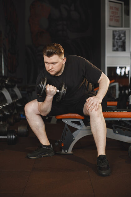 动态健身房里的运动男一个男人在做运动一个穿t恤的家伙运动员运动肌肉