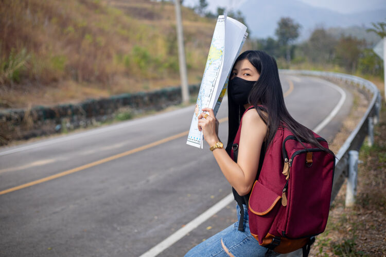 游客旅游女孩在地图上寻找正确的方向背包水平无袖