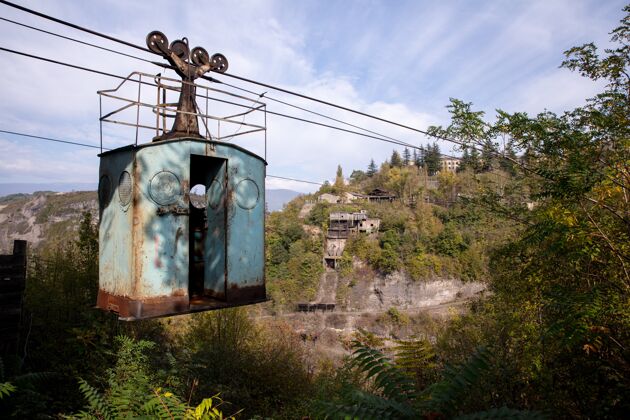 建筑低角度拍摄一个古老的废弃索道在一个多山的风景全景空中绳索