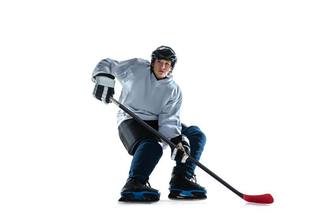 运动年轻的冰球男选手 冰球场上的棍子和白墙曲棍球比赛装备