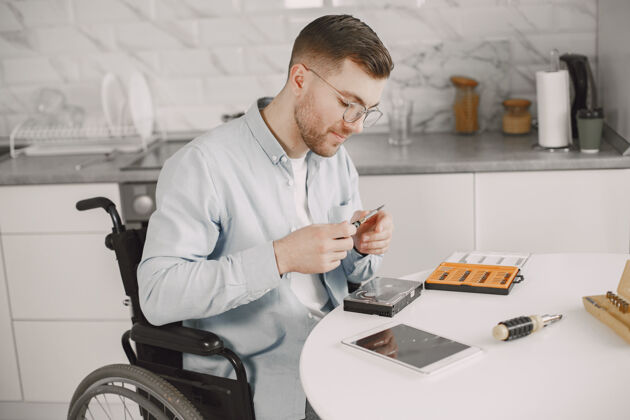 电工残疾人喜欢坐轮椅修理呆在家里 爱好工作场所工作男性