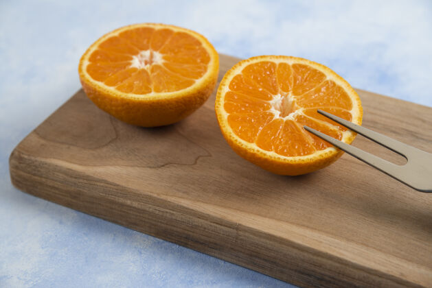食物木板上的半切克莱门廷普通话特写叶橘子自然
