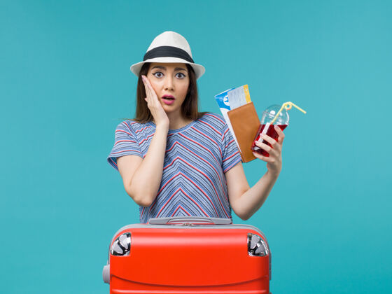 美丽前景度假中的女人拿着钱包拿着蓝色背景上的机票旅行女海飞机夏天女成人人