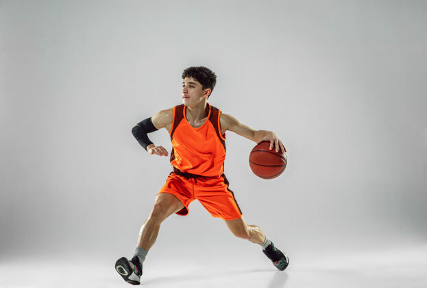 运动年轻的篮球队员穿着运动服训练 在运动中练习 在运动中奔跑隔离在白墙上人比赛篮球