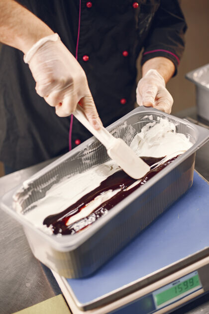 食物制作凝胶巧克力冰淇淋身着厨师制服的糖果师正在制作冰淇淋人工作黑
