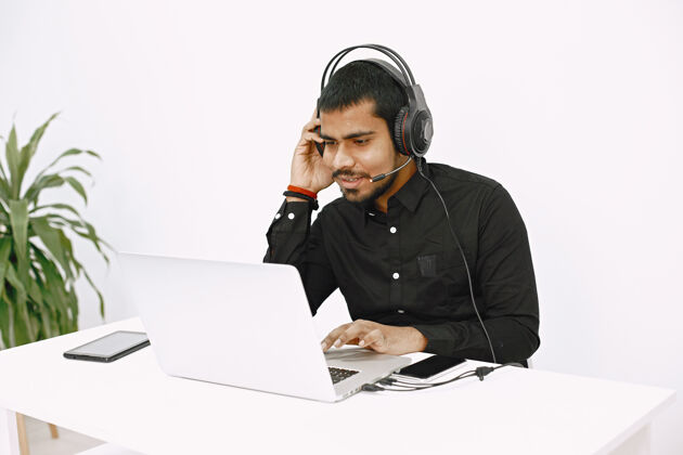 办公桌使用笔记本电脑的人印度派遣或热线工作人员工作场所专业人士人