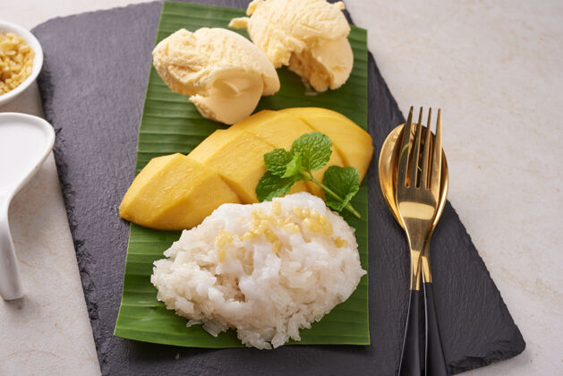 芒果成熟的芒果和糯米 冰激凌和椰子奶在石头表面 泰国甜点在夏季季节热带水果甜点水果顶视图冷椰子奶新鲜