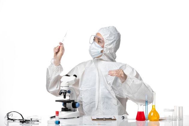 实验室外套正面图年轻女医生穿着白色防护服 戴着口罩 因为covid在浅白背景上工作 大流行性飞溅病毒covid-口罩防护医生