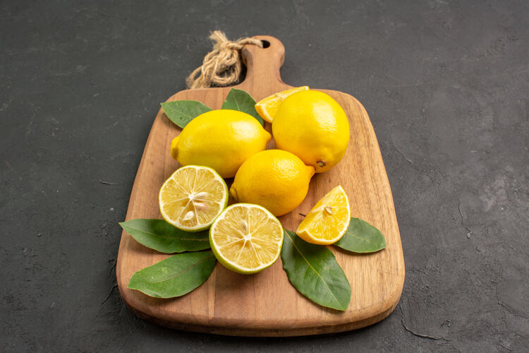 柑橘正面是深灰色背景上的新鲜柠檬酸水果树多汁柠檬