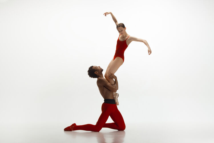 服装优雅的经典芭蕾舞者在白色的工作室背景上独立地跳舞一对穿着鲜红衣服的舞者就像是酒和牛奶的结合优雅 艺术家 动作 动作的概念动作灵活体操