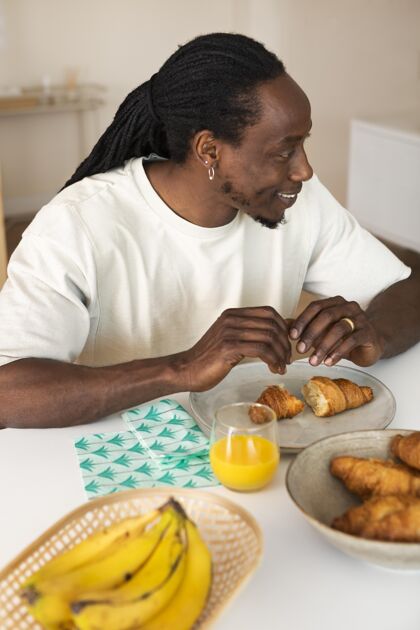 垂直快乐男人吃香蕉早餐橙汁里面香蕉