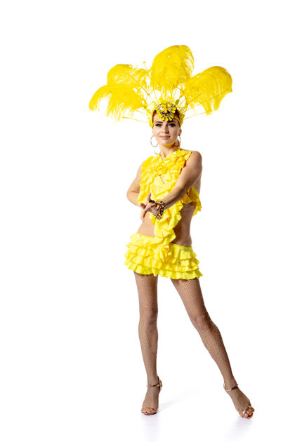 面具表演身着嘉年华化装 黄色羽毛的美丽年轻女子在白色背景上翩翩起舞节日庆典 节日时间 舞蹈 聚会 快乐的概念复制空间华丽德意大利