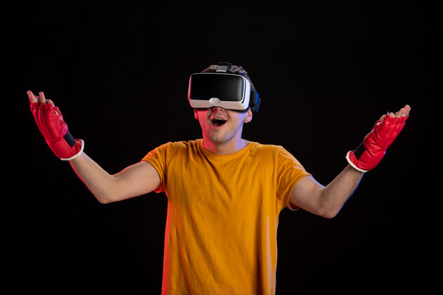 游戏在黑暗的表面上戴着mma手套玩虚拟现实的年轻男性游戏成人现实