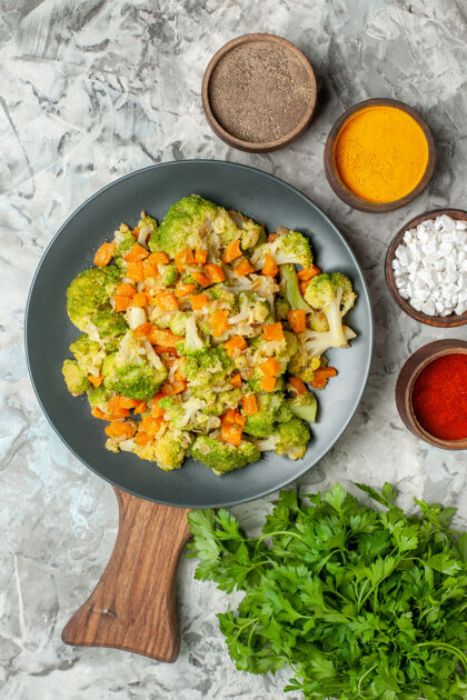 美食健康蔬菜沙拉的垂直视图不同的香料和一堆绿色的白色桌子上一餐饮食沙拉