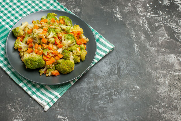 美味绿色条状毛巾上的新鲜健康蔬菜沙拉俯视图 灰色桌子上正餐饮食盘子