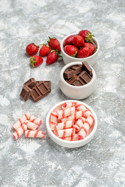 糖果灰白色桌子上有草莓巧克力糖果和一些草莓巧克力糖果的底视图碗食品甜点可食用水果