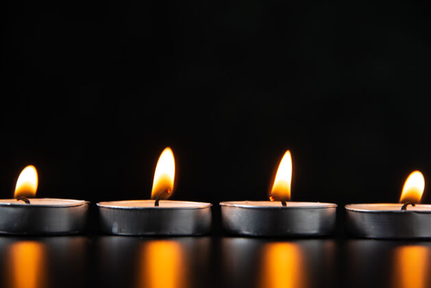 死亡在黑暗的表面上燃烧蜡烛的前视图蜡烛表面火