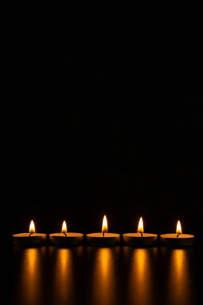 蜡烛在漆黑的表面燃烧蜡烛的正面图夜黑暗死亡