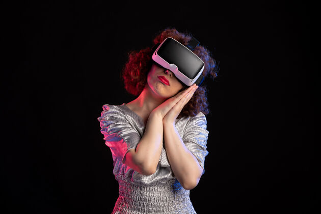 虚拟年轻女性戴着虚拟现实耳机在黑暗的表面成人人耳机