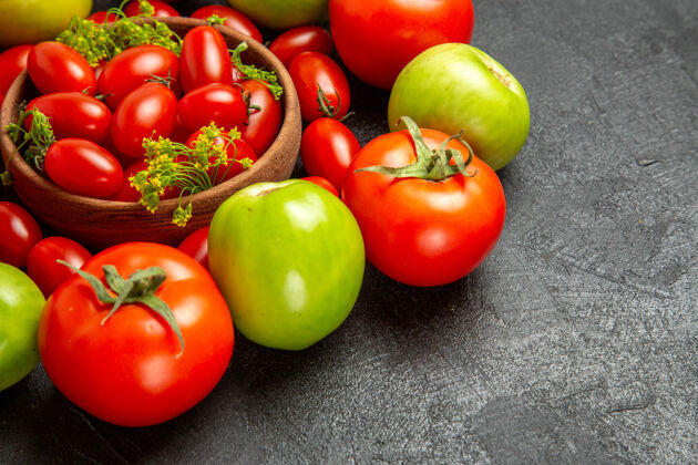 蔬菜底部近距离观看樱桃红色和绿色的西红柿围绕着一个碗 深色背景上有樱桃西红柿和莳萝花底部地樱桃