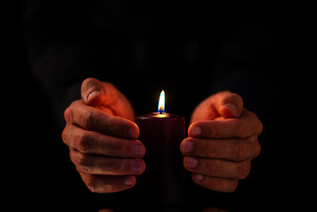 火焰黑蜡烛的正面图 公蜡烛在黑暗的表面上黑打火机黑暗