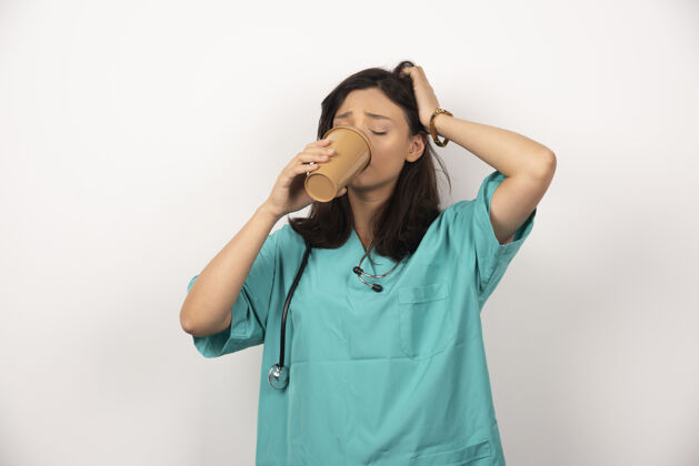 工作女医生喝着白底咖啡高质量的照片女性医生保健
