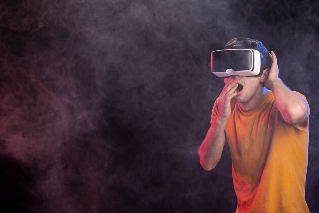 人在虚拟现实黑暗的表面上玩恐怖游戏的年轻男性年轻男性护目镜游戏