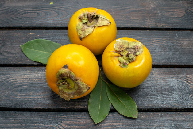 素食正面是新鲜甜甜的柿子 放在木质质朴的书桌上 水果醇香的树上有机饮食树