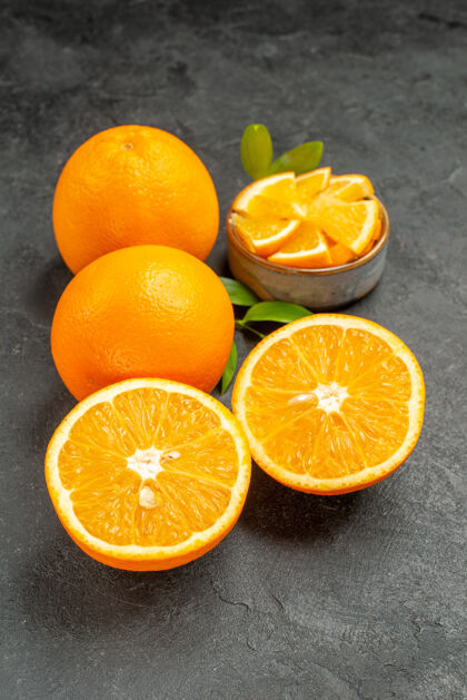 健康一组黄色的整体和切割柠檬在黑暗背景下的垂直视图甜橙深色柠檬