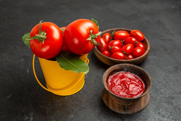 番茄底视图一桶西红柿碗樱桃西红柿和番茄酱在黑暗的背景樱桃成熟减肥