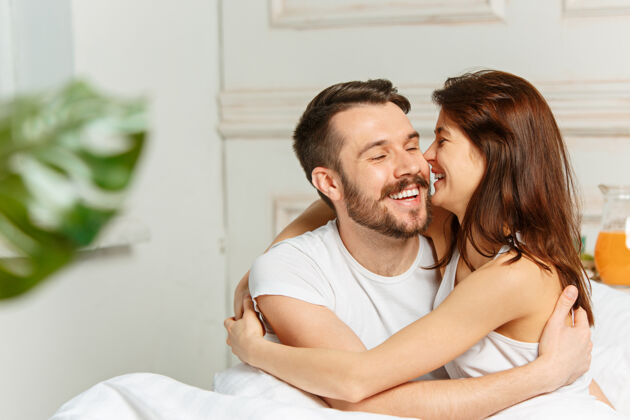 爱年轻的异性恋夫妇躺在卧室的床上白种人人床
