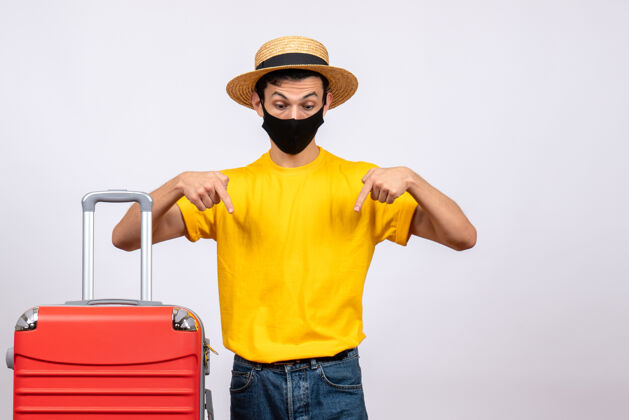手提箱正面图：一个穿着黄色t恤和红色手提箱的年轻人指着下面年轻人前面黄