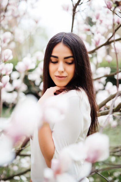 成人美丽的少女在一个盛开着木兰花的花园里木兰花盛开 柔情肖像女性樱花