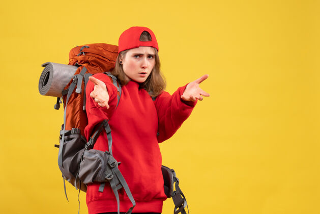 前面正面图：年轻的女旅行者 手拿背包背包手够着